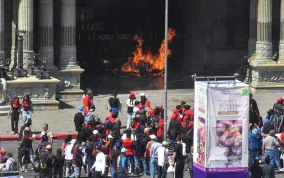 Encapuchados prenden llamarada frente al Palacio Nacional durante desfile bufo