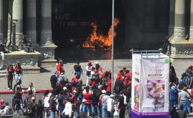 Encapuchados prenden llamarada frente al Palacio Nacional durante desfile bufo